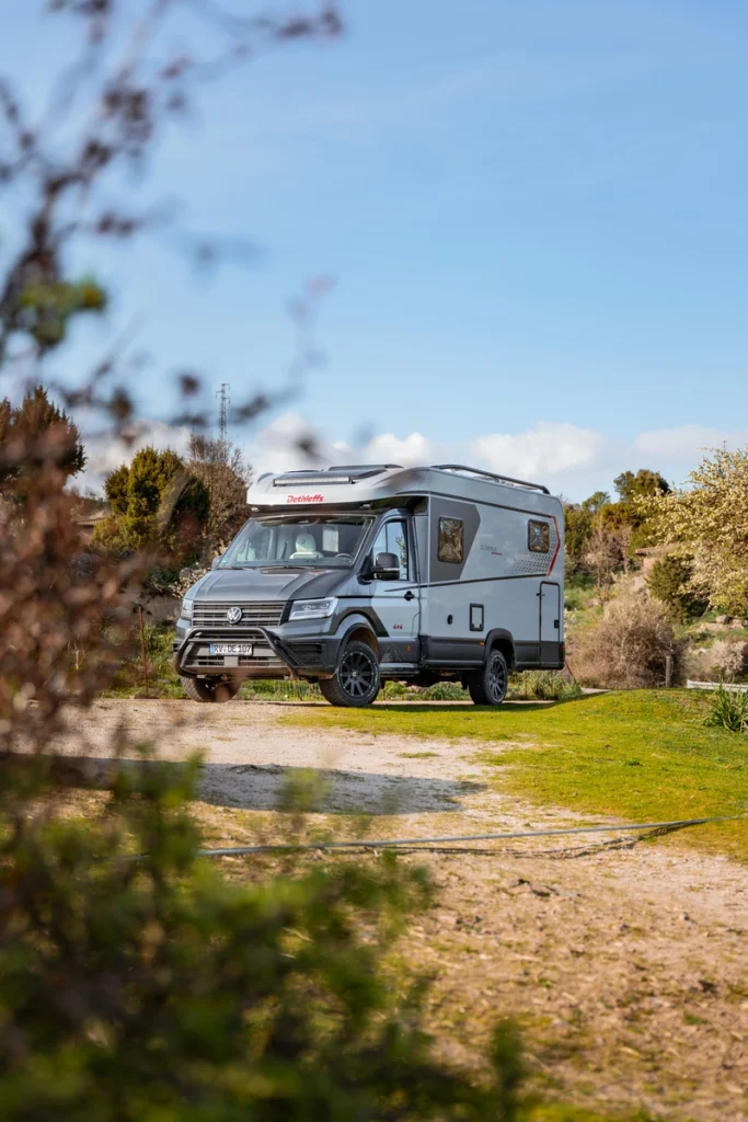 Un camping car profilé Dethleffs arrêté au milieu d'un sentier