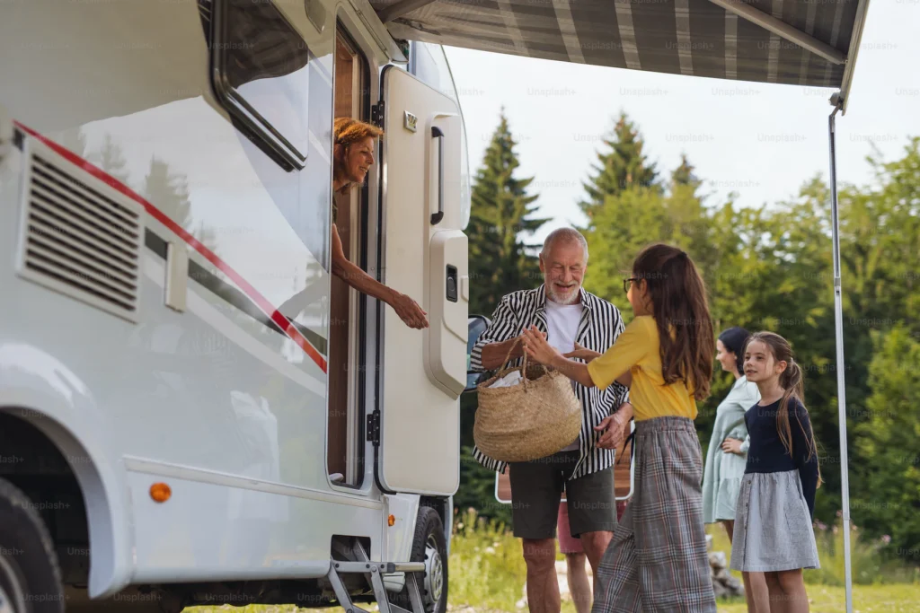 une famille qui rentre dans un camping-car avec de la nouriture